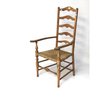 A 20th century oak ladder back kitchen chair. With a rush seat, raised on turned supports, H117cm