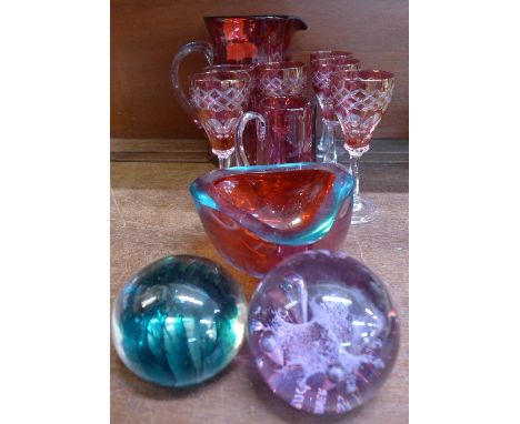 A set of six Bohemian glasses, two Cranberry glass jugs, large one a/f, two glass paperweights including Caithness and a glas