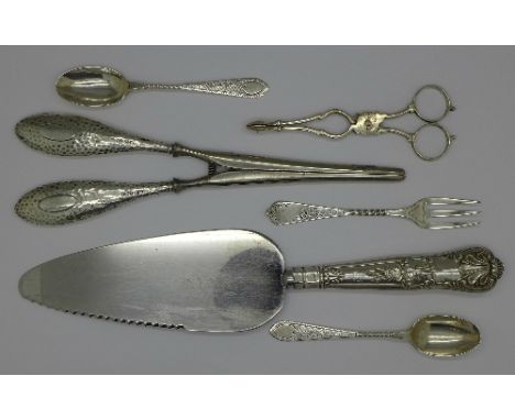 A pair of silver sugar nips, two silver spoons, a plated fork, a pair of silver handled glove stretchers and a silver handled