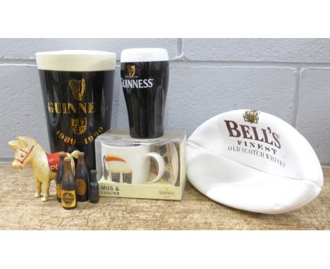 A large pottery Guinness pint glass money bank, one smaller, a Guinness mug and coaster set, boxed, four miniature Guinness b