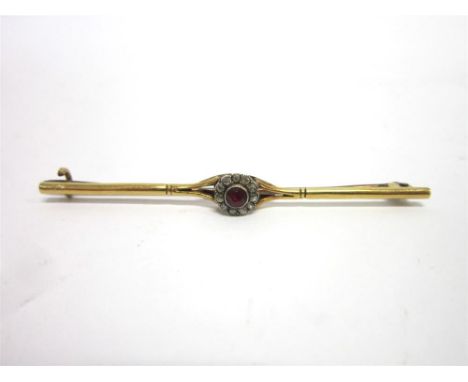 A DIAMOND AND RUBY CLUSTER BAR BROOCH possibly converted from a ring, the round cut ruby enclosed by eleven single cut diamon