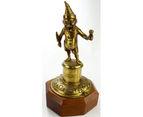 Brass Mr Punch table / counter lighter, mounted on an octagonal plinth, total height 24cm approx.