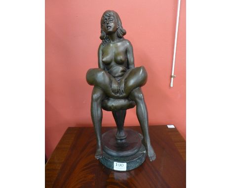 A bronze figure of a seated female nude on a marble base