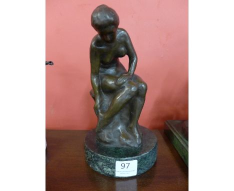 A bronze figure of a female nude, on green marble socle