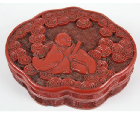 A Chinese cinnabar lacquer box and cover, of mirror form, decorated with a seated male figure with scroll amid stylised cloud