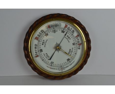 A round oak framed aneroid barometer with rope carved detail to frame, 34cm diam