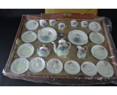 A French porcelain child's part breakfast service, decorated with pansy flowers, includes coffee pot, milk and sucrier cups, 