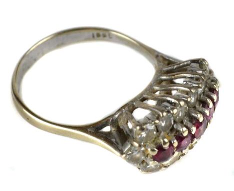 A 1970's ruby and diamond cluster ring, with a central row of five small circular cut rubies surrounded by brilliant cut diam