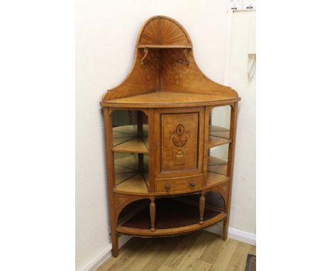 A free standing satinwood corner unit, central small cupboard over drawer with two shelves either mirrored sides over lower l