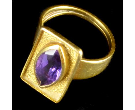 A 1970's 18ct yellow gold and amethyst ring, the rectangular gold plaque set to the centre with a collet set marquise shaped 