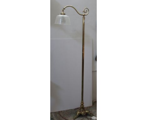 A brass standard lamp with downward hanging etched shade, fluted column tripod base with claw feet
