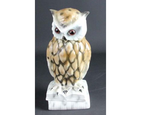 A German porcelain owl form perfume lamp of Aerozon type, modelled as a bird perched on a pile of books, glass, illumination 