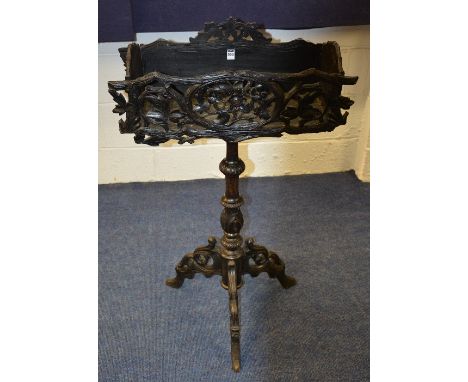 A Gothic style carved planter, decorated with pierced floral panels, above turned column and tripod supports, 105cm high x 66
