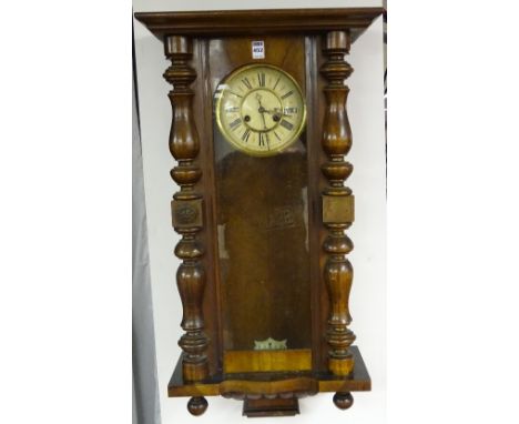 A mahogany Vienna wall clock, the cream enamel dial with Roman numerals, lacking weights and pendulum, 84cm high x 44cm wide 