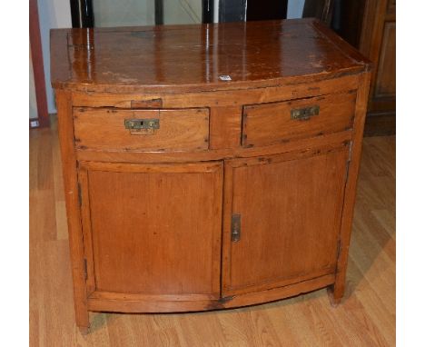 A hardwood bow-front cupboard chest, with two small drawers above two panelled doors, 76cm high x 80 cm wide x 51cm deep