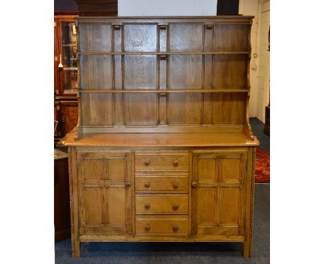 An Ercol 'Golden Dawn' dresser, with two tier delft rack above four small central drawers, flanked by panelled door, 181cm hi