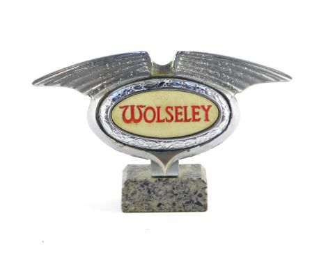 A Wolseley mid 20thC chrome light up grill badge, raised on a marble base, 16cm wide. 
