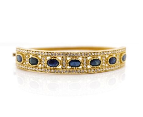 Sapphire and 14ct yellow gold hinged bangle with a cubic zirconia surround. Marked 585. Approx weight 17.3 grams, inside widt