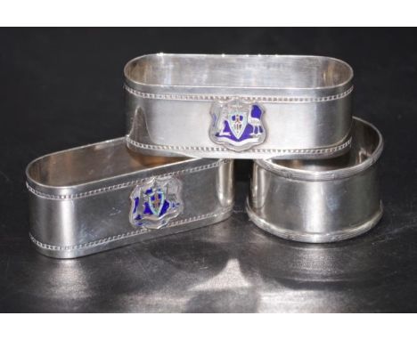 Pair sterling silver napkin rings each with applied coat of arms, and monogrammed; together with a George V sterling silver n