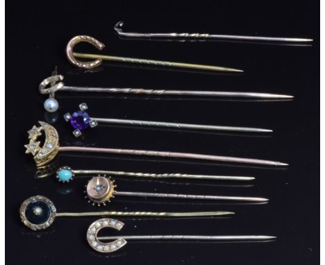 Two Edwardian 9ct gold stick pins in the form of horseshoes, a Victorian 9ct gold stick pin set with a diamond and other anti