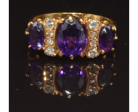 An 18ct gold ring set with three oval cut amethysts and diamonds, size L, 4.4g