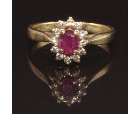 A 9ct gold ring set with an oval ruby surrounded by diamonds, size K, 2.2g