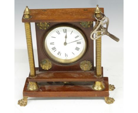 French brass mantel clock mounted on mahogany frame with brass pillar supports, raised on paw feet, the enamel Roman dial wit