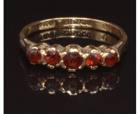 A 9ct gold ring set with garnets, size K, 1.7g
