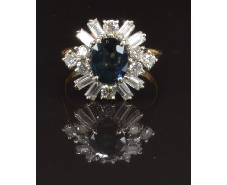 An 18ct gold ring set with an oval cut sapphire surrounded by baguette and round cut diamonds, size H, 3g