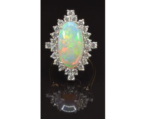 An 18ct gold ring set with a large oval opal cabochon of approximately 4ct surrounded by 24 round cut diamonds, each approxim