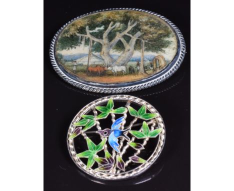 A silver brooch set with a painted ivory plaque and a silver brooch set with enamel&nbsp;