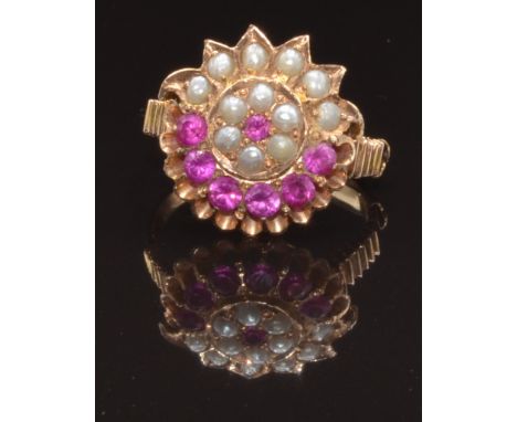 A yellow metal ring set with round cut rubies and seed pearls in a cluster, size K, 4.3g