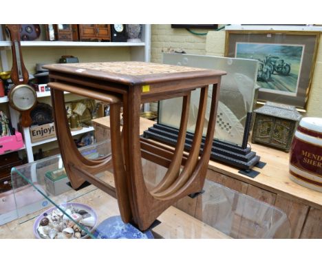 A vintage nest of three rosewood tables, the largest with tile inset top, 50cm wide.&nbsp; 