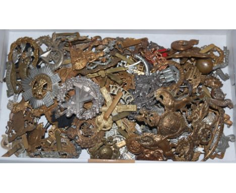 A Royal Artillery brass helmet plate, together with a large collection of cap badges and insignia to include Scottish King's 