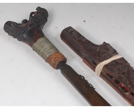 A mid-20th century Dayak headhunter's sword, having an etched steel blade and carved wooden handle, in a wooden scabbard, 73c