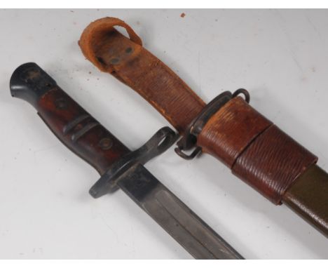 A U.S. model 1917 Remington bayonet, having a 43cm single edged fullered blade and two piece wooden grip, in a leather mounte