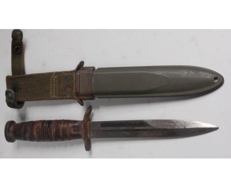 A US Army M3 trench knife, having a 16.5cm steel blade, the crossguard stamped US M3 UTICA, the eight groove leather grip wit
