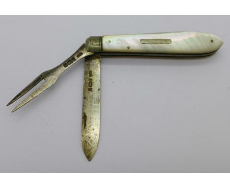 A silver knife and fork combination with mother of pearl handle