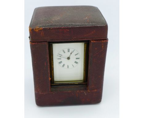 A small carriage clock with travel case and key, height of clock 72mm