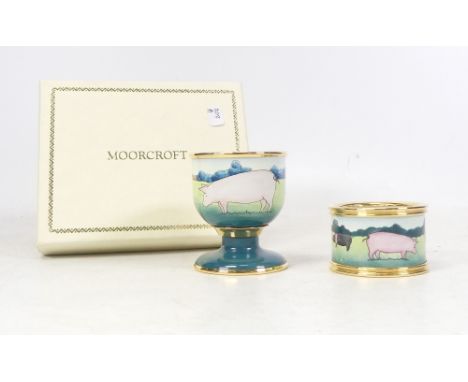 Moorcroft Enamels, Egg Cup and Napkin Ring set painted with Pigs in a Field. Boxed. (2)