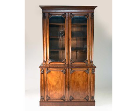 A 19th century mahogany library bookcase, the cavetto cornice above twin glazed panel doors with acanthus leaf corner spandre