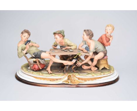 A Capodimonte figural group of ‘The Card Cheats’ designed by Bruno Merlicirca 1970swith impressed signature, on a plinth base