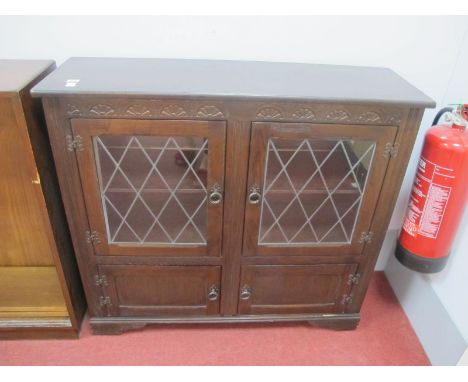 A XX Century Oak Cabinet, with twin leaded glazed doors, two small drawers on bracket feet.