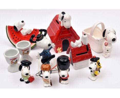 11 Ceramic Peanuts Snoopy Figures. Various types including - Snoopy laying on a slice of water melon, Snoopy sitting on kenne