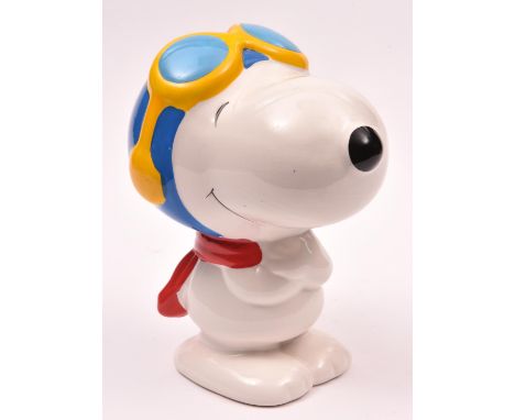 A large ceramic Snoopy character money box standing with red scarf in blue flying helmet and with goggles up. 19cm high. Endo