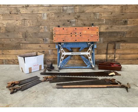 A collection of hand tools vintage hand tools including saws, a vice, drill bits and a work bench