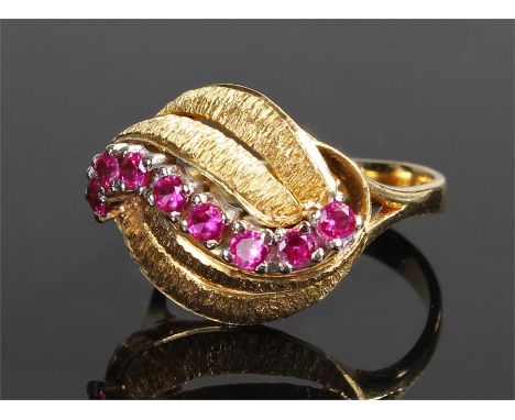 18 carat gold ruby ring, with an arched band of rubies between two pairs of leaf design bands, ring size N