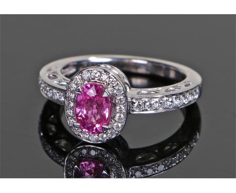 18 carat white gold, diamond and ruby ring, the central oval ruby ring with a diamond surround and further diamonds to the sh