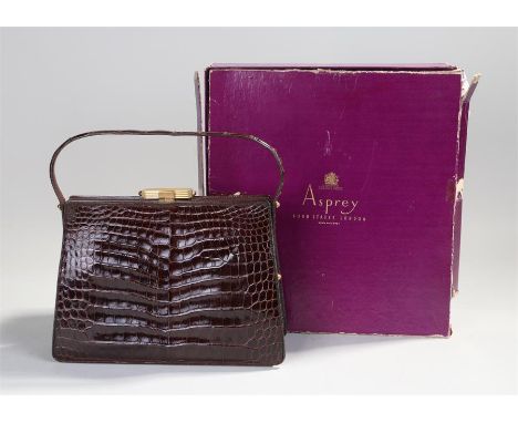 Asprey crocodile leather handbag, with a gilt metal clasp set with cabochon stone to either end, the bag 25cm wide