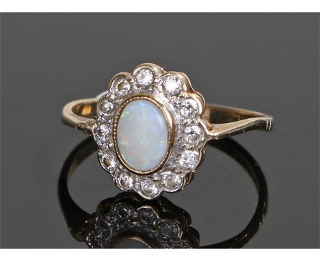 9 carat gold opal and diamond set ring, the central oval opal with diamond surround, ring size L